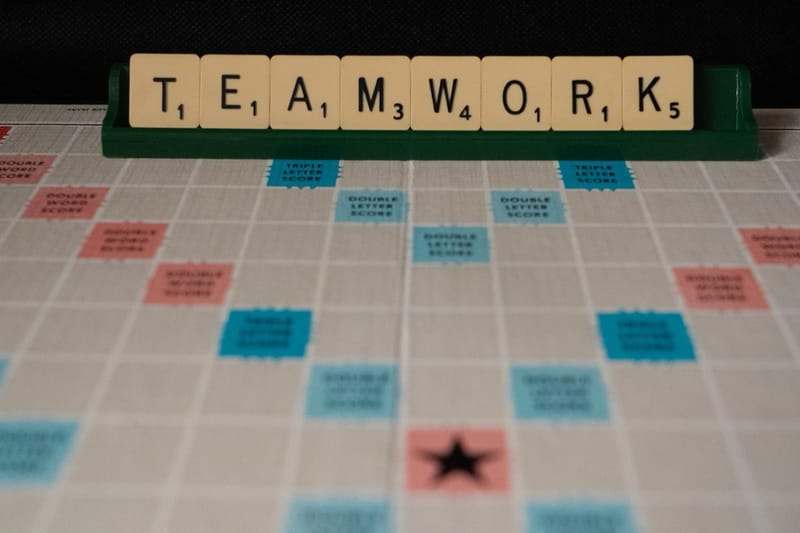 Scrabble board spelling the word TEAMWORK, representing Double2's collaborative culture